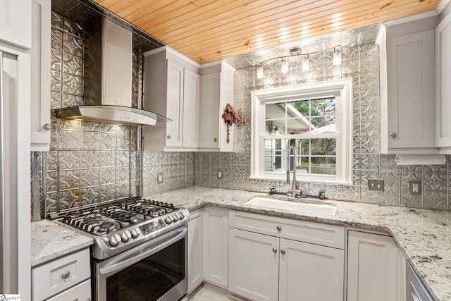 kitchen with stainless steel range with gas stovetop, wooden ceiling, wall chimney range hood, white cabinets, and sink