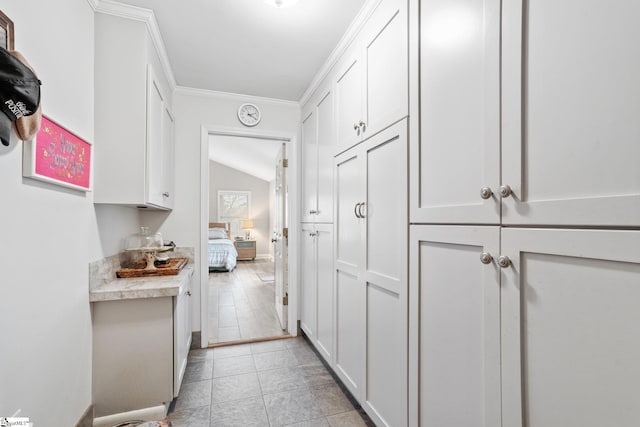 hallway with lofted ceiling and crown molding