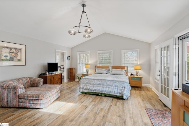 bedroom featuring light wood-type flooring, a chandelier, and multiple windows