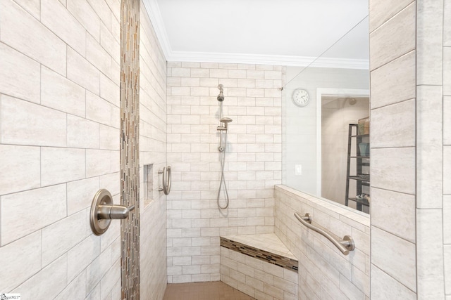 bathroom with ornamental molding and a tile shower