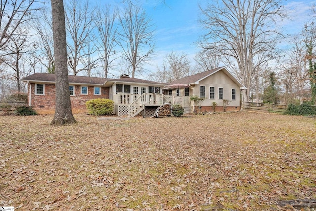 rear view of property featuring a wooden deck