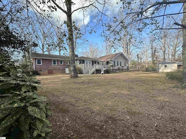 rear view of property featuring a storage unit