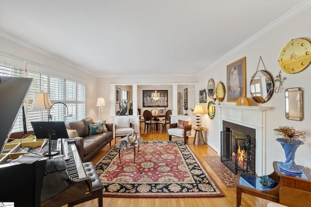 living room with a brick fireplace, ornamental molding, and hardwood / wood-style floors