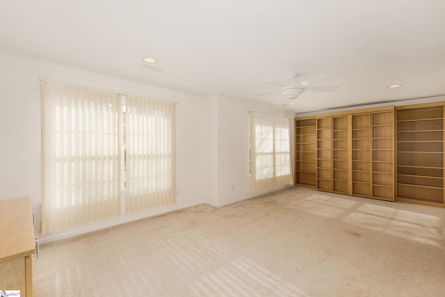 unfurnished bedroom featuring light colored carpet and ceiling fan