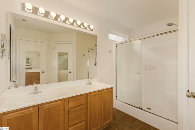 bathroom featuring tile patterned flooring, vanity, and a shower with door