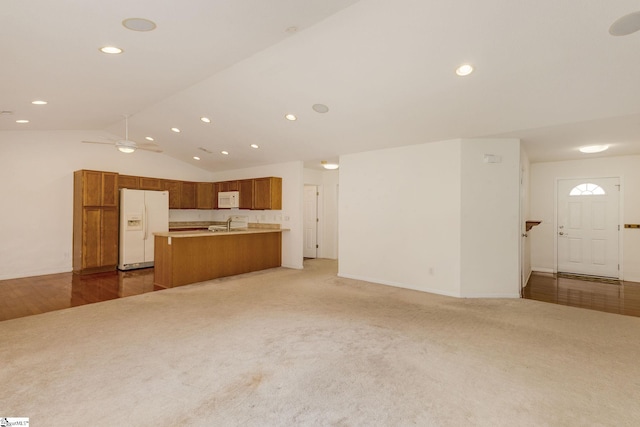 unfurnished living room featuring wood-type flooring, ceiling fan, lofted ceiling, and sink