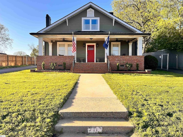 bungalow-style home with covered porch and a front lawn