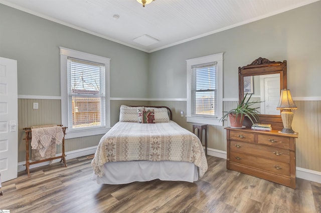 bedroom featuring wooden walls, hardwood / wood-style floors, and ornamental molding