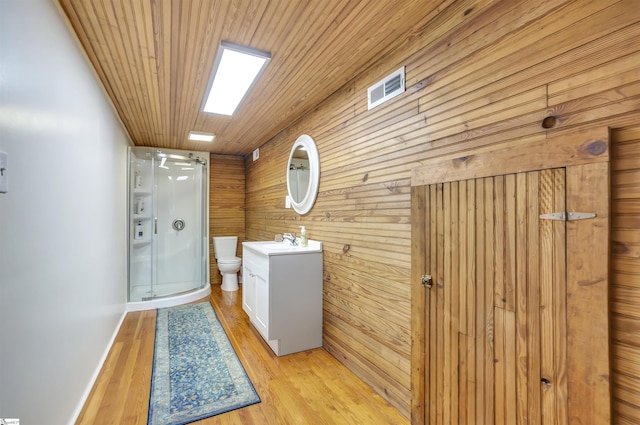 washroom with wood walls, light hardwood / wood-style flooring, ceiling fan, and wooden ceiling