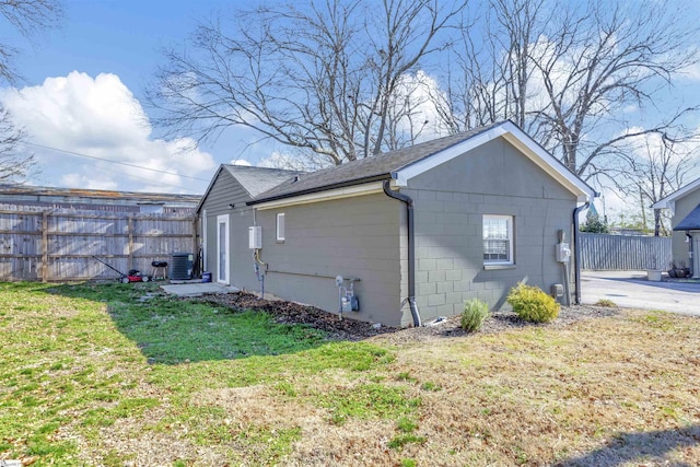 view of property exterior with central AC and a lawn