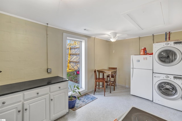 laundry area featuring stacked washing maching and dryer and ceiling fan