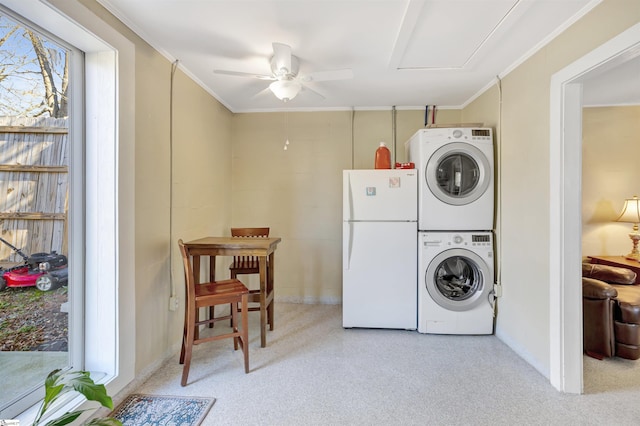 clothes washing area with light carpet, stacked washing maching and dryer, ceiling fan, and crown molding