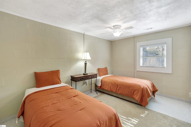 bedroom with a textured ceiling, light colored carpet, and ceiling fan