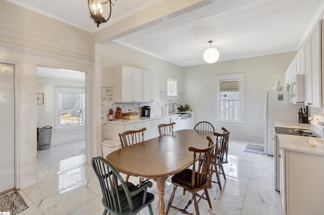 dining area with crown molding and sink