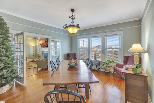 dining area featuring light hardwood / wood-style floors and crown molding