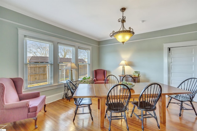 dining room with light hardwood / wood-style floors and crown molding