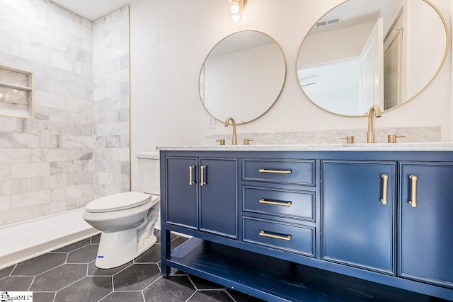 bathroom with tile patterned flooring, vanity, and toilet