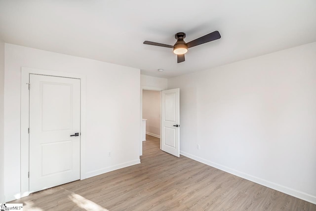 unfurnished bedroom featuring ceiling fan, light hardwood / wood-style floors, and a closet