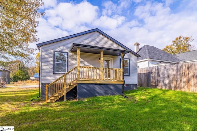 back of property with a porch and a lawn