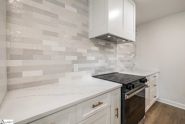 kitchen with stainless steel electric stove, dark hardwood / wood-style flooring, white cabinetry, and tasteful backsplash