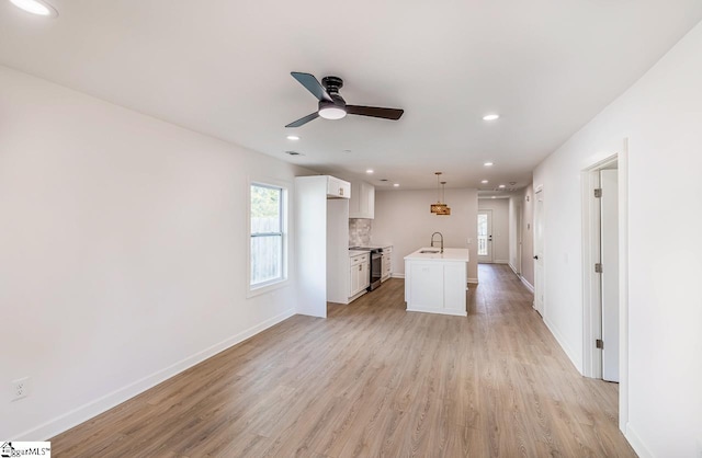 interior space with light hardwood / wood-style floors, ceiling fan, and sink