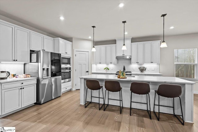 kitchen with pendant lighting, white cabinets, and stainless steel appliances