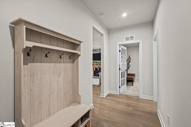 mudroom with light hardwood / wood-style floors