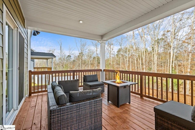 deck with an outdoor living space with a fire pit