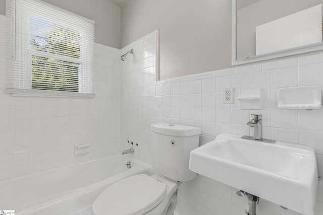 full bathroom featuring tiled shower / bath, tile walls, and toilet