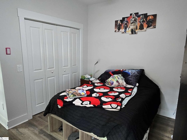 bedroom with dark hardwood / wood-style floors and a closet