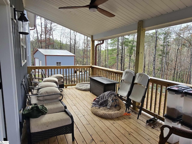 wooden deck with ceiling fan and an outdoor structure