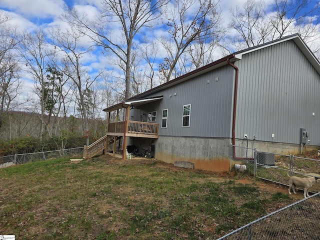 back of property with a deck and a yard