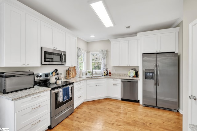 kitchen with white cabinetry, light hardwood / wood-style flooring, stainless steel appliances, and sink