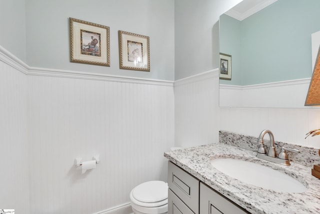 bathroom featuring vanity, ornamental molding, and toilet