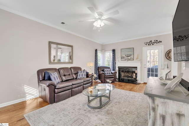 living room featuring ceiling fan, light hardwood / wood-style floors, and ornamental molding