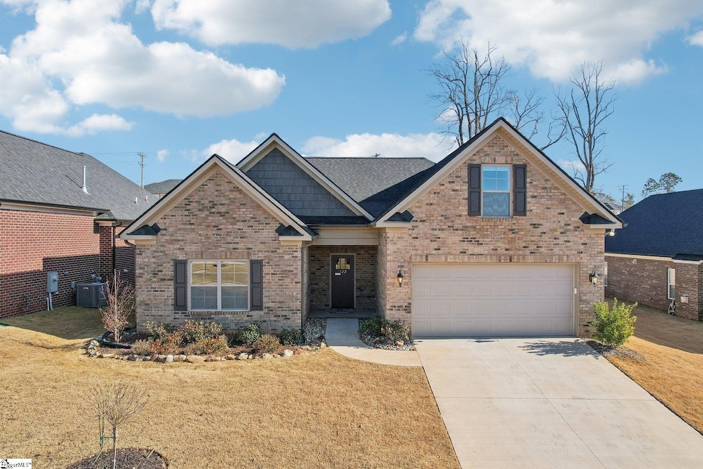 craftsman house with a front lawn, a garage, and central AC unit