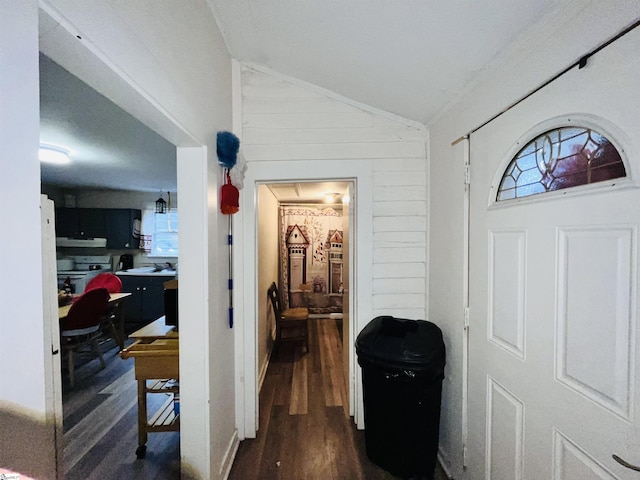 entryway with wooden walls, dark hardwood / wood-style floors, and vaulted ceiling