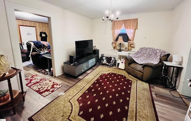 living room featuring a notable chandelier, wooden walls, and light hardwood / wood-style flooring