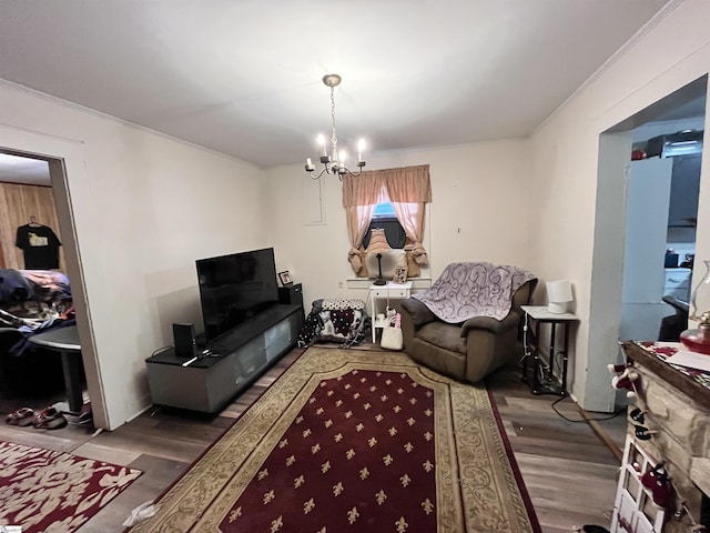 living room featuring wood-type flooring, an inviting chandelier, and ornamental molding