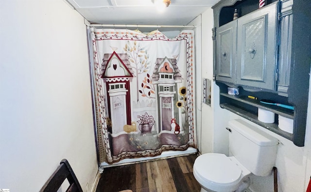 bathroom with wood-type flooring, toilet, and a shower with curtain