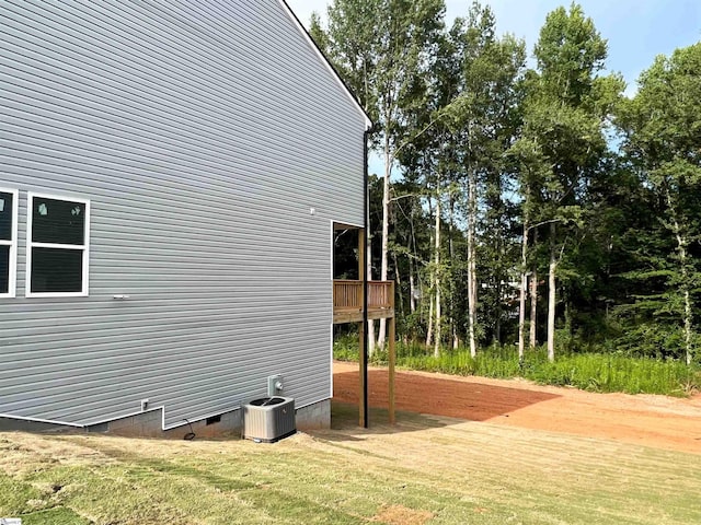 view of property exterior featuring a lawn and central AC unit