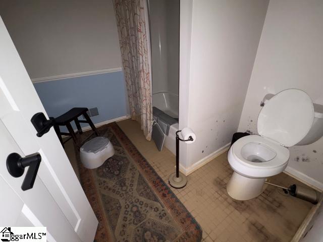 bathroom featuring toilet and shower / tub combo