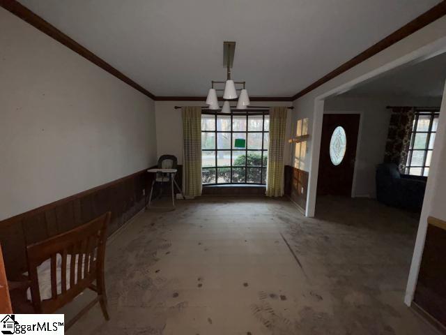 entryway featuring crown molding, a wealth of natural light, and a notable chandelier