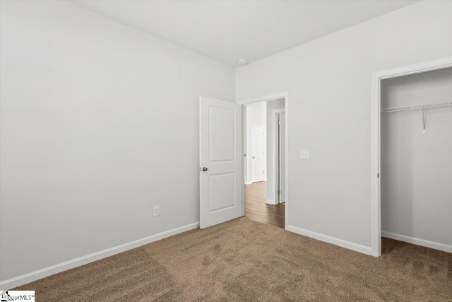 unfurnished bedroom featuring a closet and carpet flooring