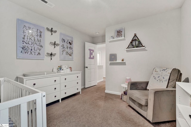 bedroom with light colored carpet and a nursery area