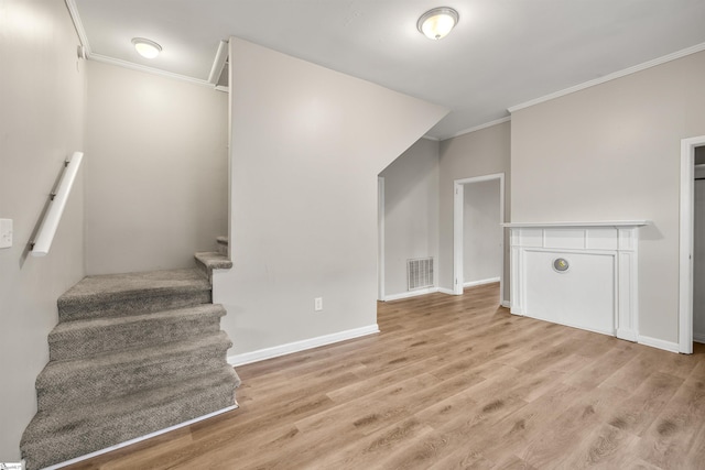 stairs featuring crown molding and wood-type flooring