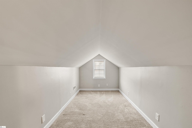 additional living space with light colored carpet and lofted ceiling