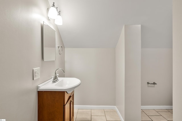 bathroom featuring tile patterned floors, vanity, and vaulted ceiling