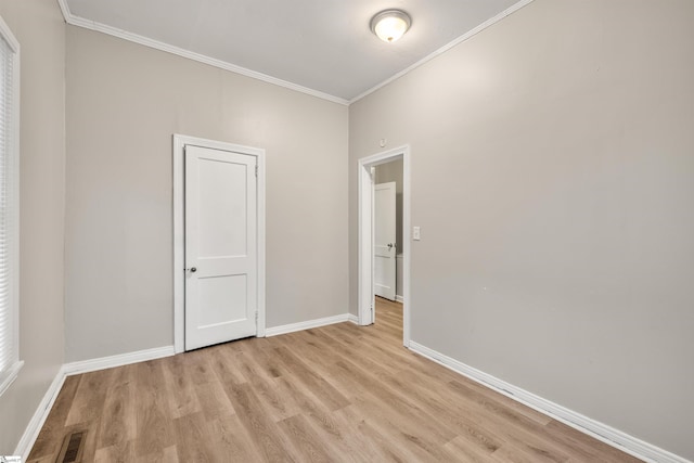 spare room with crown molding and light hardwood / wood-style flooring