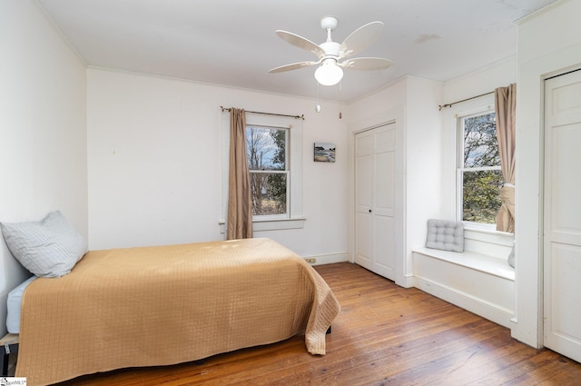 bedroom featuring wood-type flooring, ceiling fan, and ornamental molding